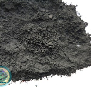 May include: A close-up of a pile of black powder. The powder is fine and has a slightly grainy texture.