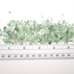 Puede incluir: Un mont&oacute;n de peque&ntilde;as piedras preciosas de aventurina verde pulidas. Las piedras son de varios tonos de verde, con algunas &aacute;reas transl&uacute;cidas. Una regla con medidas en pulgadas se coloca junto a las piedras preciosas.