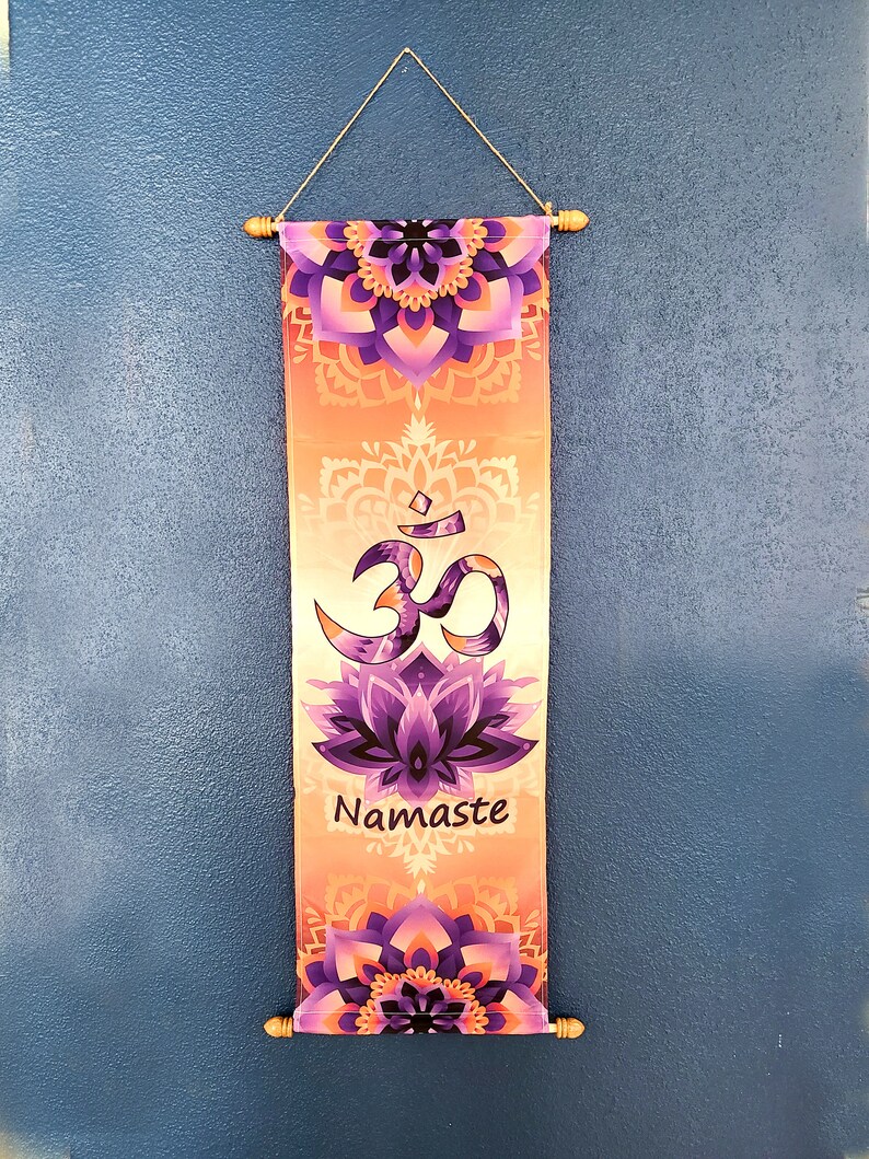 May include: A decorative wall hanging with a purple and orange mandala design. The hanging features the Om symbol and the word "Namaste" in a white font.