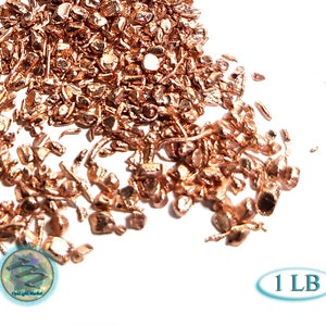 May include: A pile of copper shavings, a metallic reddish-brown color, on a white background. The text "1 LB" is visible in the lower right corner of the image.