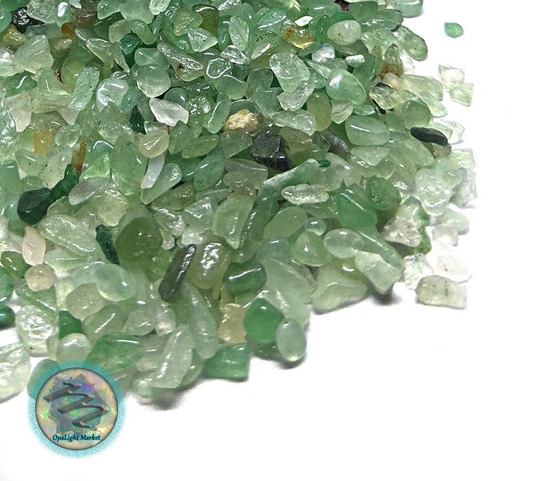 Puede incluir: Primer plano de un mont&oacute;n de peque&ntilde;as piedras de aventurina verde pulidas. Las piedras var&iacute;an en tonos de verde, de claro a oscuro, y tienen un aspecto ligeramente transl&uacute;cido. Las piedras tienen forma irregular y parecen pulidas.