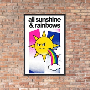 May include: A framed art print with the words "all sunshine & rainbows." The artwork features a yellow sun with an angry expression, spewing a rainbow from its mouth. The background has pink and blue geometric shapes.