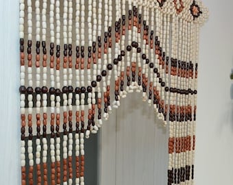 May include: A wooden bead curtain with a geometric pattern in brown and white. The curtain is hanging in a doorway.