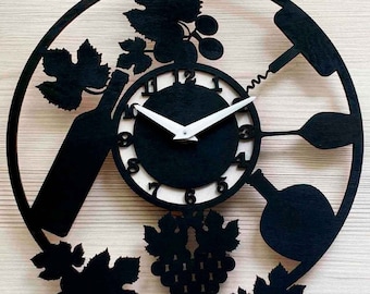 May include: Black and white wooden wall clock with a wine theme. The clock features a wine bottle, grapes, a corkscrew, and wine glasses. The clock face is white with black numbers.