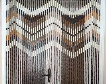 May include: A brown, white, and beige beaded curtain with a geometric pattern. The curtain is hanging in a doorway.