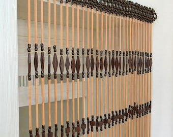 May include: A beaded door curtain with a natural wood finish. The curtain features long, vertical wooden rods strung with dark brown beads in various shapes, including diamond and square designs. The top is a woven pattern of dark brown beads.