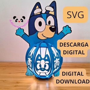 Peut inclure: Une lanterne en papier bleue en forme de chien de dessin animé avec le texte "SVG" et "TÉLÉCHARGEMENT NUMÉRIQUE". La lanterne a un design détaillé et est éclairée de l'intérieur. Le design comprend un logo panda et les mots "A.RiveraCreations".