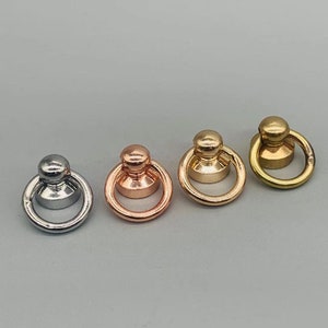 Puede incluir: Tres anillos de metal con parte superior abovedada. Los anillos son plateados, de oro rosa y de oro.