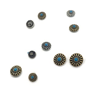 Op de afbeelding: Assortiment van decoratieve metalen bloemvormige knopen met turquoise centra. Sommige knopen zijn zilver en sommige zijn goud.
