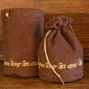 May include: Two brown velvet pouches with gold embroidery. The pouches have the text "goes ever on and on" embroidered on them.