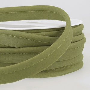 May include: A spool of olive green bias binding with a stitched edge.