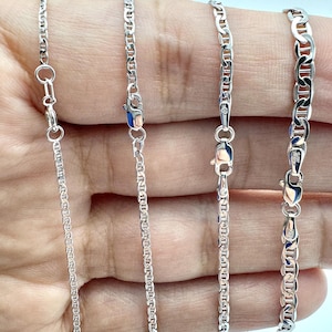 May include: Four silver-toned mariner link chains with lobster claw clasps, displayed in varying widths labeled as 1.5mm, 1.9mm, 2.4mm, and 3.05mm. Each chain features a polished metallic finish and a consistent oval link design with a central bar.