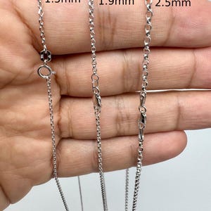 May include: Three silver-colored rolo chains with round links, displayed with labels indicating widths of 1.5mm, 1.9mm, and 2.5mm. Each chain features a circular spring ring clasp or lobster claw clasp, showcasing the varying link sizes side by side.