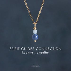 May include: A gold-colored chain necklace with a pendant featuring three gemstone beads: a small gold bead, a light blue bead, and a dark blue bead. The text "SPIRIT GUIDES CONNECTION kyanite . angelite" is below the necklace.
