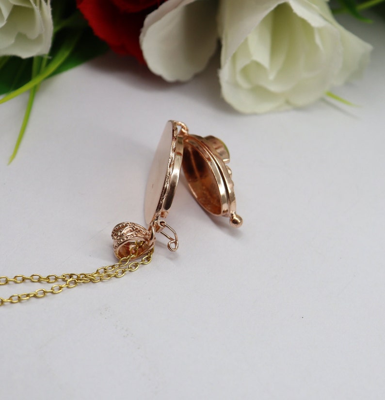 May include: A gold-toned locket necklace with a delicate chain. The locket is open, revealing a smooth, empty interior.