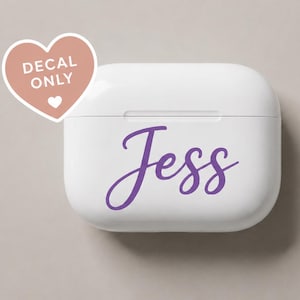 May include: A white rectangular wireless earbud charging case featuring the name Jess in purple cursive script. A pink heart-shaped sticker in the upper left corner contains the white text DECAL ONLY with a small heart icon below the text.