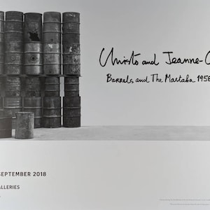 Può includere: Una fotografia in bianco e nero di un uomo in piedi accanto a una pila di barili. L'immagine è un poster promozionale per una mostra d'arte intitolata "Barrels and The Mastaba 1958-2018" degli artisti Christo e Jeanne-Claude. La mostra si tiene alle Serpentine Galleries di Londra, Inghilterra, dal 19 giugno al 9 settembre 2018.