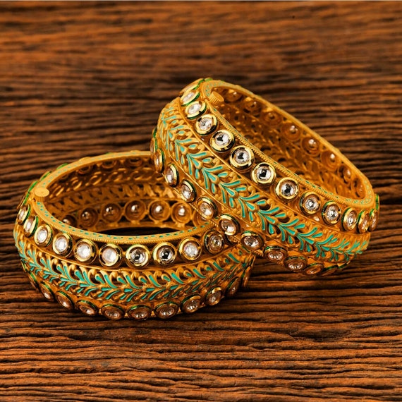 A pair of gold plated kundan bangles Size 2.2