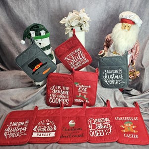 May include: Set of 10 red and gray Christmas themed oven mitts with various sayings. The sayings include "Let's bake stuff and watch Christmas movies", "Tis the season for baking cookies", "Cutest elf on the block", "Bake some Christmas cheer", "Mrs. Claus North Pole Bakery", "Christmas calories don't count", "Christmas baking queen", "Gingerbread Taster".