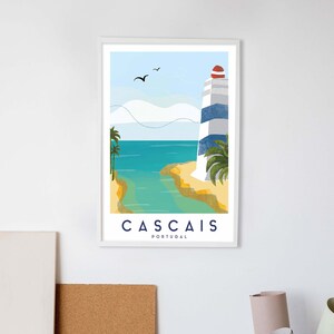 May include: Framed art print featuring a coastal scene with a lighthouse. The lighthouse has blue and white stripes and a red top. The print includes the text "Cascais Portugal" and depicts palm trees, ocean, and birds.