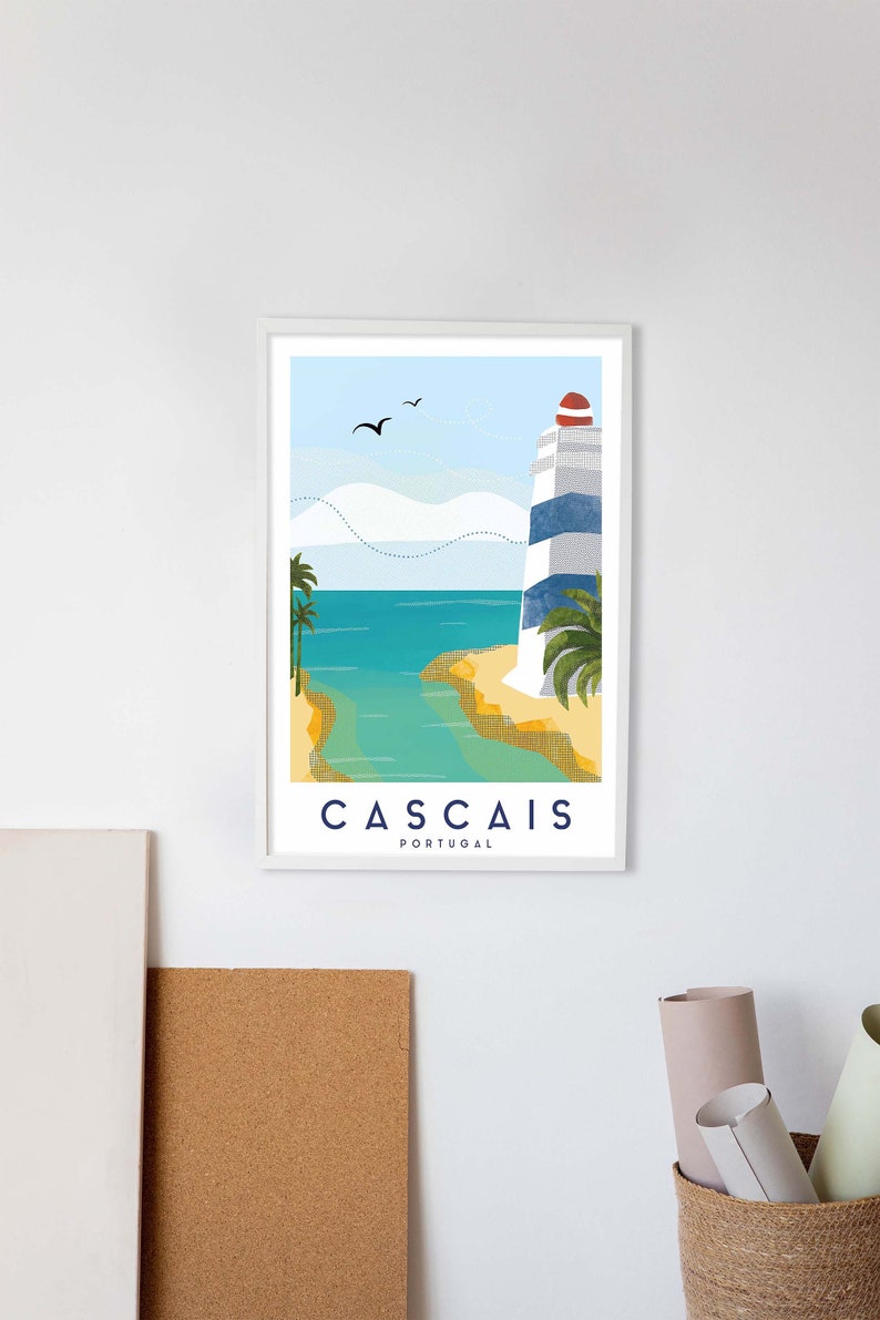 May include: Framed art print featuring a coastal scene with a lighthouse. The lighthouse has blue and white stripes and a red top. The print includes the text "Cascais Portugal" and depicts palm trees, ocean, and birds.