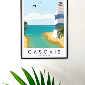May include: Framed art print featuring a coastal scene with a lighthouse, palm trees, and the text "CASCAIS PORTUGAL." The lighthouse has blue and white stripes and a red top. The artwork depicts a beach and ocean under a blue sky with birds.