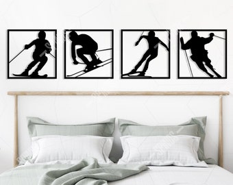 Op de afbeelding: Vier zwarte metalen wanddecoraties met silhouetten van skiërs in verschillende poses. De stukken zijn in een rij op een witte muur boven een bed met een lichtgrijze dekbedovertrek geplaatst.