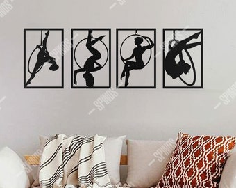 Könnte beinhalten: Vier schwarze Metall-Wandkunstwerke, die Luftakrobaten in verschiedenen Posen zeigen. Jedes Stück ist rechteckig mit einer Silhouette einer Person auf einem Reifen oder Stoff. Der Text "SPINOS WALL DECOR" ist unten in Schwarz gedruckt.