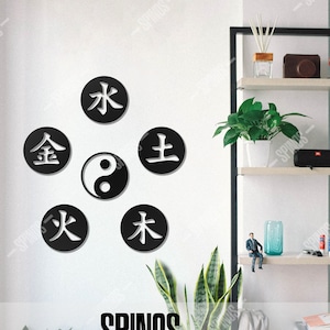 May include: Black and white wall decor featuring the five elements of Chinese philosophy: wood, fire, earth, metal, and water. The decor also includes a yin yang symbol.