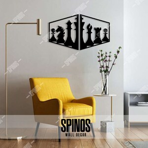 May include: Black metal wall decor featuring a chess set design. The decor is mounted on a white wall in a living room setting with a yellow armchair and a side table with a vase of flowers.
