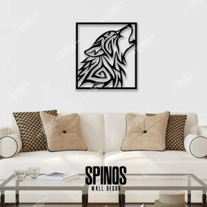 May include: Black metal wall decor featuring a stylized wolf howling at the moon. The wolf is outlined in black and has a tribal design. The decor is framed in a black square frame. The text "SPINOS WALL DECOR" is displayed below the image.