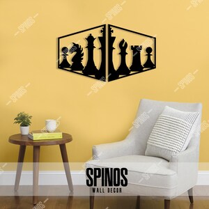 May include: Black metal wall decor featuring a chess set design. The chess pieces are silhouetted against a yellow wall. The decor is mounted on a wall in a living room setting with a chair and a side table.