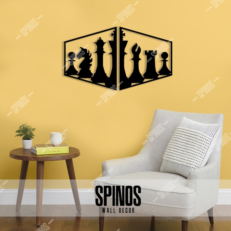 May include: Black metal wall decor featuring a chess set design. The chess pieces are silhouetted against a yellow wall. The decor is mounted on a wall in a living room setting with a chair and a side table.