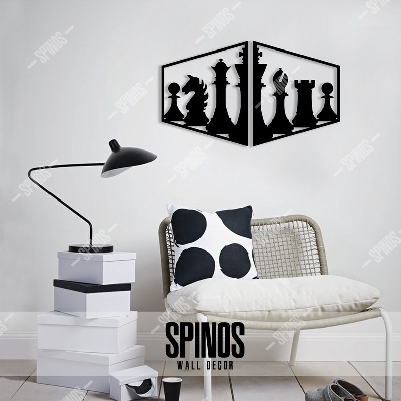 May include: Black metal wall decor featuring a chess piece design. The chess pieces are arranged in a diagonal line, with the king and queen in the centre. The decor is mounted on a white wall, with a white chair and a lamp in the foreground. The text "SPINOS WALL DECOR" is visible at the bottom of the image.