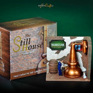 Puede incluir: Una réplica en miniatura de un alambique de la destilería Kilbeggan, parte de la colección The Still House. El modelo está hecho de cobre y presenta un telón de fondo de pared de ladrillo con un letrero que dice "Kilbeggan Distillery".