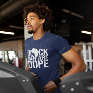 This is a picture of an African American man wearing a Shirt for BLACK MAN. It is a t shirt for aBlack male that says Black Men are DOPE t shirt