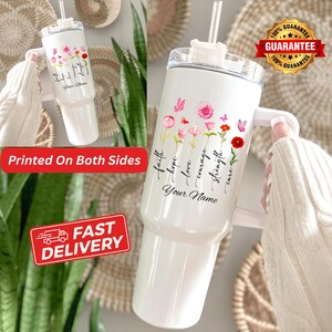 May include: White insulated tumbler with a handle, featuring a floral design with pink and red flowers, butterflies, and the words "faith, hope, love, courage, strength, cure" and "Your Name". Includes a straw and a lid.