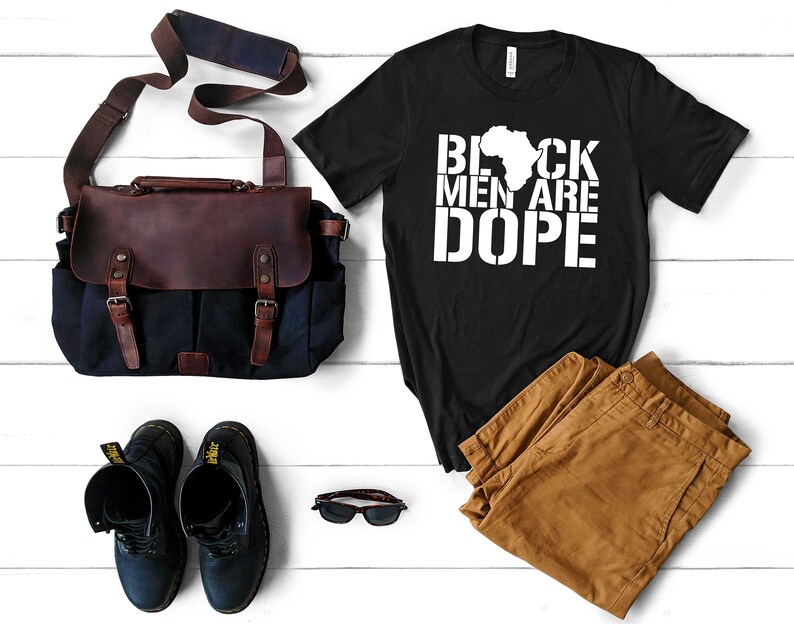 This is a picture of an African American man wearing a Shirt for BLACK MAN. It is a t shirt for aBlack male that says Black Men are DOPE t shirt