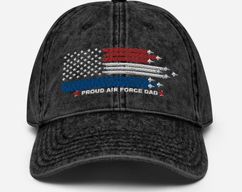May include: A black distressed denim baseball cap with an embroidered American flag and the text "Proud Air Force Dad".