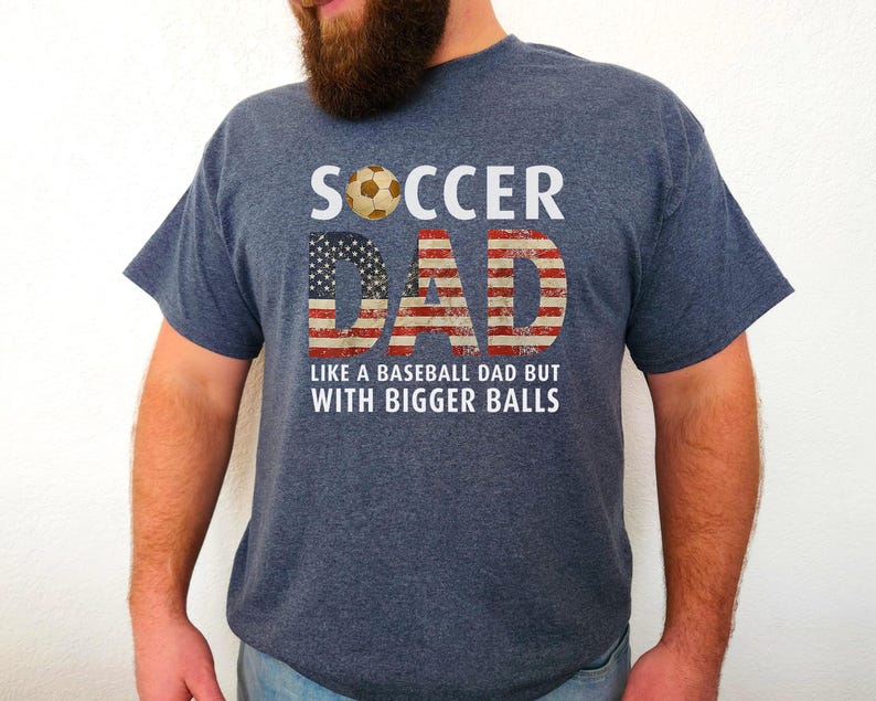 Men’s soccer dad t shirt featuring American flag text and soccer ball graphic, funny soccer dad design on heather navy blue shirt
