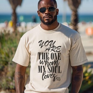 Man wearing matching Christian husband t shirt with faith based scripture at beach