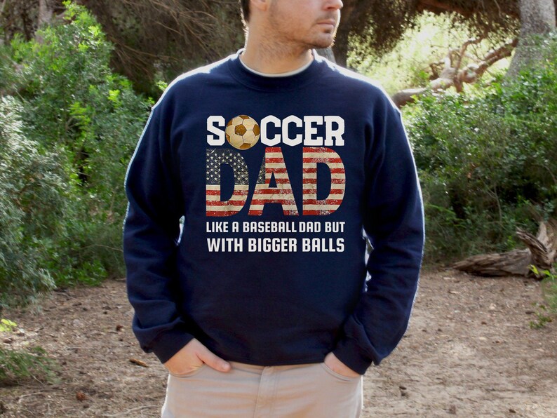 Funny soccer dad crewneck sweatshirt with patriotic American flag lettering, men’s soccer dad top worn outdoors