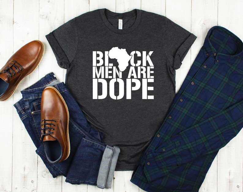 This is a picture of an African American man wearing a Shirt for BLACK MAN. It is a t shirt for aBlack male that says Black Men are DOPE t shirt