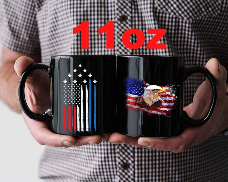 This is a picture of a patriotic coffee mug. The mug is black. The mug has the US flag and a patriotic flyover on one side and on the other side of the mug is a beautiful American Bald Eagle with the American flag