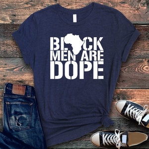 This is a picture of an African American man wearing a Shirt for BLACK MAN. It is a t shirt for aBlack male that says Black Men are DOPE t shirt