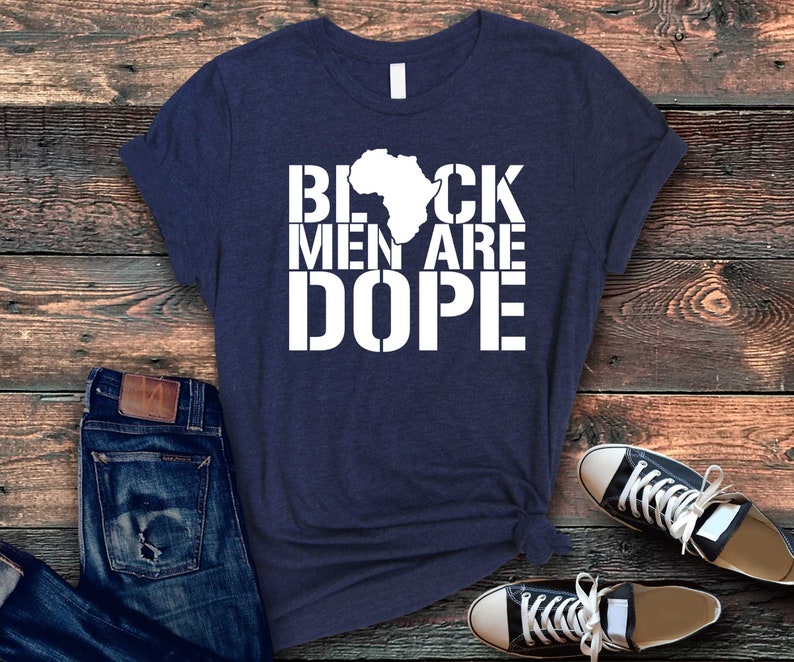 This is a picture of an African American man wearing a Shirt for BLACK MAN. It is a t shirt for aBlack male that says Black Men are DOPE t shirt