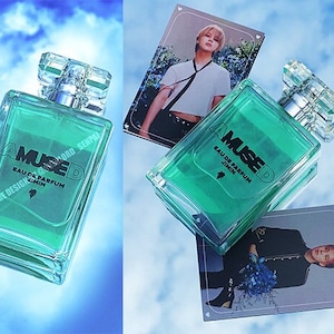 May include: A clear glass bottle of perfume with a green liquid. The bottle is labeled "AMUSED EAU DE PARFUM JIMIN".