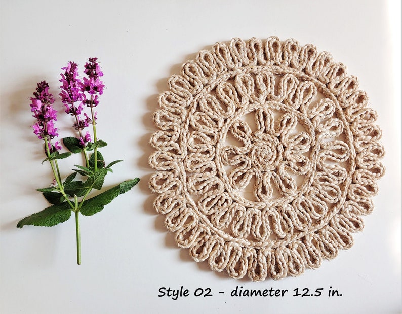 May include: A round, beige, crocheted coaster with a floral design. The coaster is 12.5 inches in diameter. Style 02.