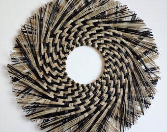 May include: Black and natural woven wall hanging with a circular shape and a fringe border. The woven design features a spiral pattern. The text "KHCREATIONSHOP" is visible at the bottom of the image.