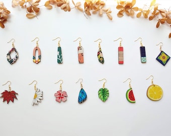 May include: Assortment of 16 pairs of colorful wooden earrings with various designs, including floral, geometric, and nature-inspired patterns. The earrings are displayed on a white background.
